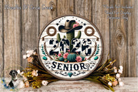 A decorative sign with the text "2026 SENIOR" surrounded by various floral elements, including a cactus, flowers, and a cowboy hat. The sign is placed on a wooden surface, with a floral arrangement in the foreground.