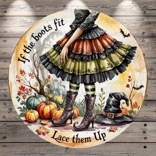 A whimsical illustration of a witch in a colorful, ruffled dress standing in a garden surrounded by pumpkins, bats, and a witch's hat. The text "If the boots fit, lace them up" is displayed around the witch, suggesting a playful or humorous message.