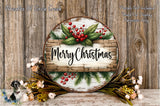 A round wooden sign with the text "Merry Christmas" displayed on it, surrounded by a wreath of greenery and red berries. The sign is placed on a wooden surface, and there are additional floral arrangements in the background.