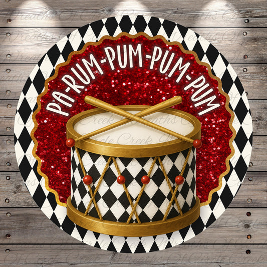 a drum with a black and white checkered pattern and red glitter accents, surrounded by a decorative border with the text "PAP-RUM-PUM-PUM" written on it.