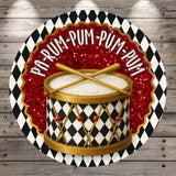 a drum with a black and white checkered pattern and red glitter accents, surrounded by a decorative border with the text "PAP-RUM-PUM-PUM" written on it.