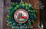 A wreath made of green foliage and a red truck with a "Special Delivery" sign on it, placed on a wooden surface.