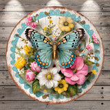 A vibrant and colorful butterfly rests on a circular wooden plate adorned with a variety of flowers, including pink, yellow, and white blooms.