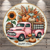 A vintage pink truck is parked on a wooden surface, surrounded by a variety of autumn-themed elements such as pumpkins, sunflowers, and leaves.
