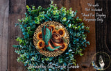 A wreath made of various green and brown foliage, with a pair of blue cowboy boots and sunflowers as the focal point.