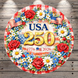 A circular wreath with red, white, and blue flowers surrounding a large number "250" and an American flag, set against a wooden background.