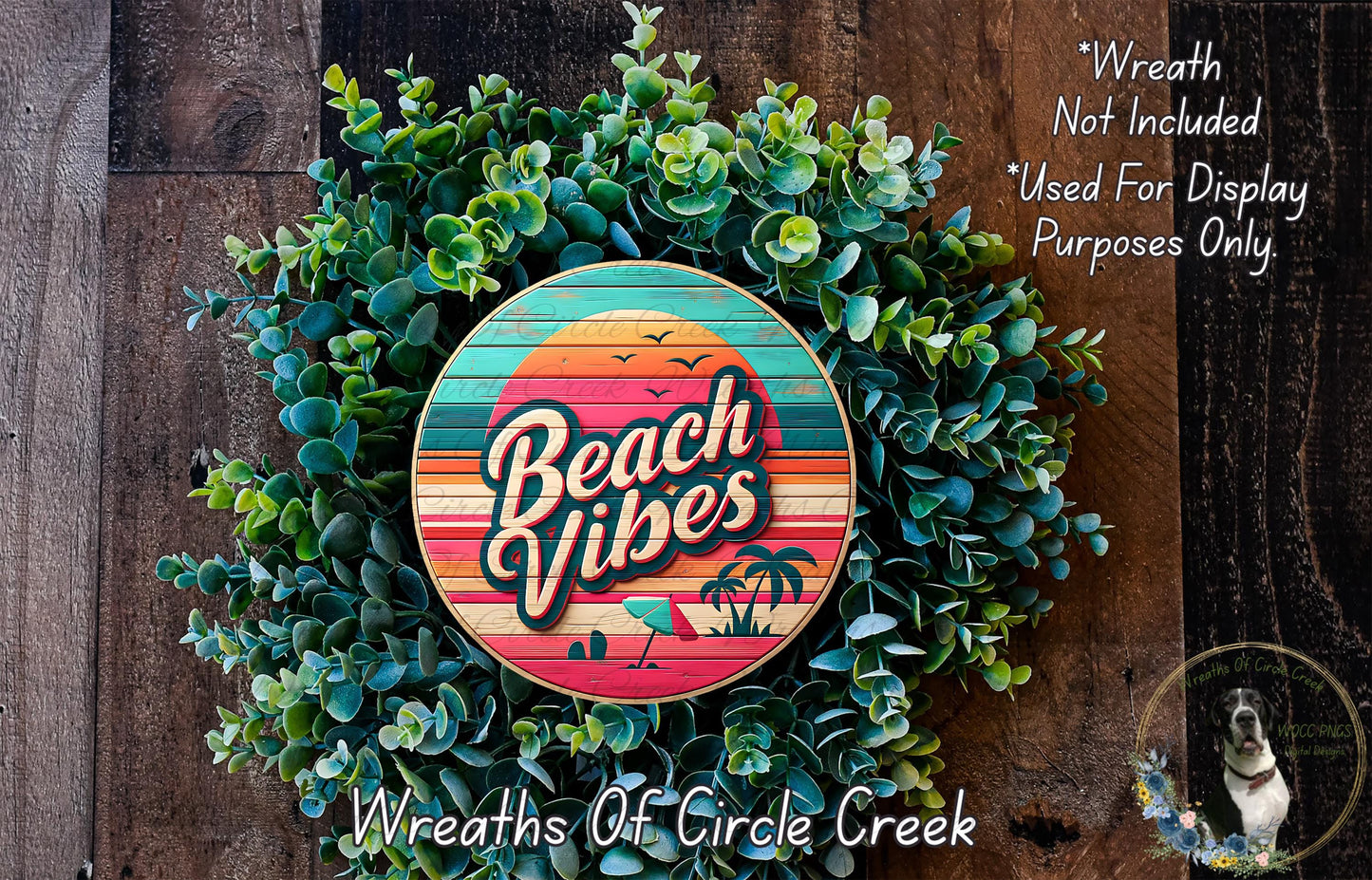 a wreath made of green plants and a circular sign with the text "Beach Vibes" on it, placed on a wooden surface.