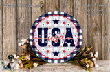 a circular sign with the word "USA" written on it, surrounded by a floral arrangement and a wooden background.