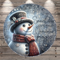 A snowman wearing a top hat and scarf, with the text "Snowflakes dance with Christmas magic" written around it, against a snowy background.