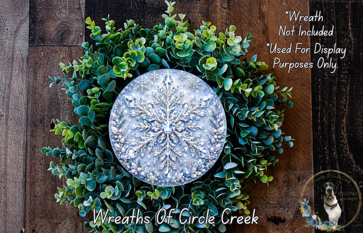 A wreath made of green leaves and a silver snowflake ornament, placed on a wooden surface.
