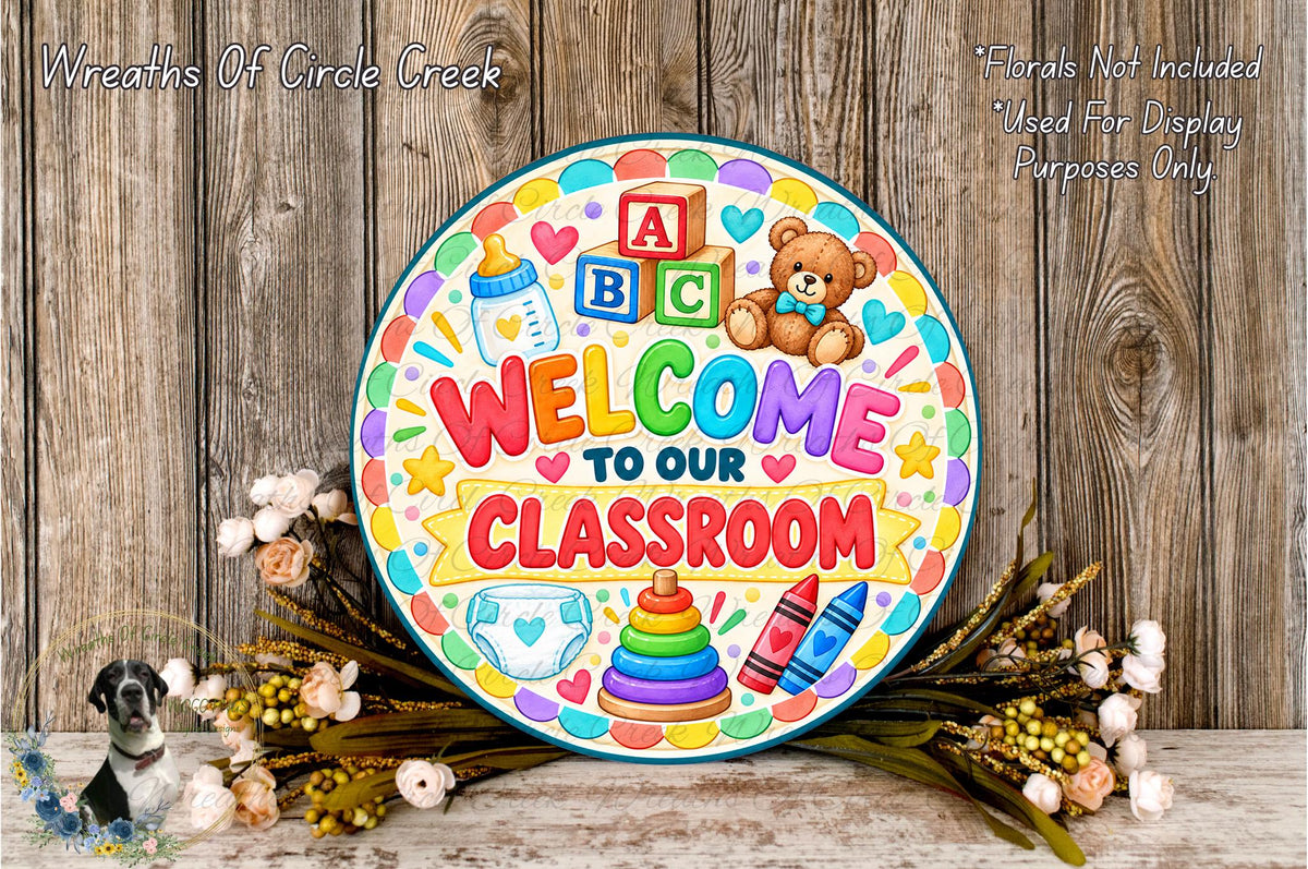 a colorful welcome sign for a classroom, surrounded by flowers and a teddy bear.