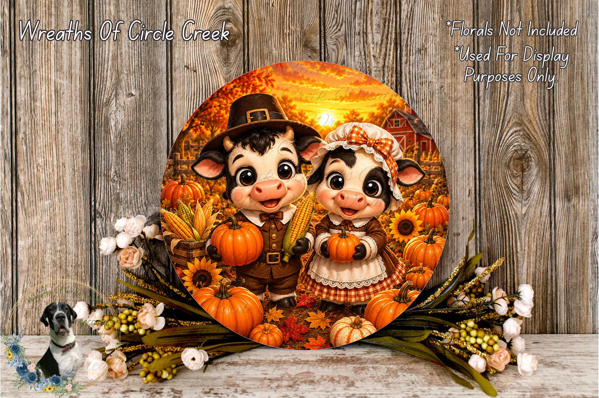 A circular wreath featuring two cartoon cows, one wearing a hat and the other a dress, surrounded by autumn-themed elements such as pumpkins, sunflowers, and a wooden fence.