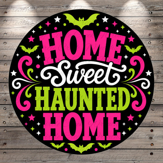 a circular graphic with the text "HOME Sweet Haunted Home" in a stylized font, surrounded by decorative elements such as bats, stars, and swirls in pink, green, and white colors.