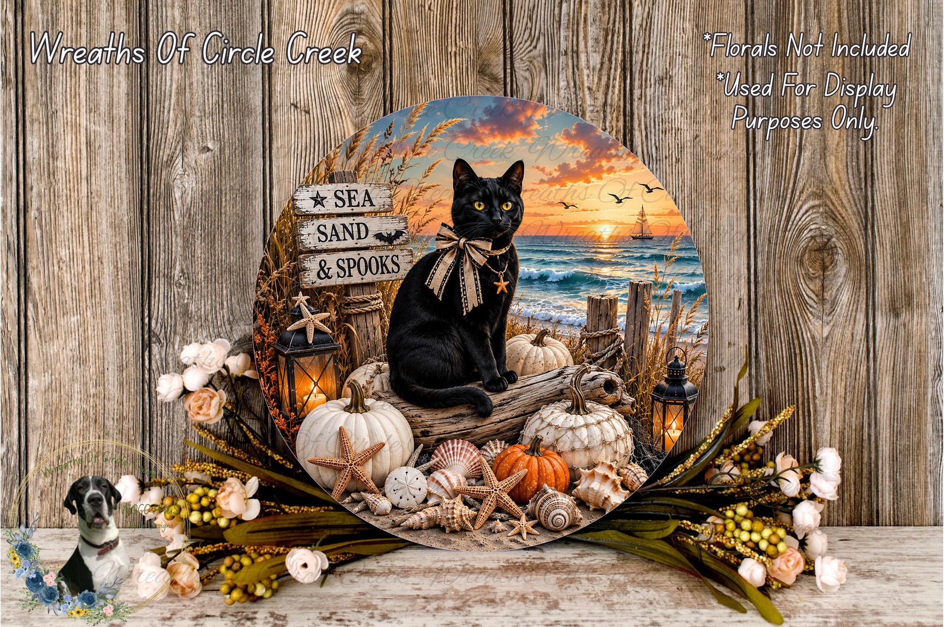 A black cat sits on a log surrounded by autumn decorations, including pumpkins, seashells, and a lantern, against a backdrop of a sunset over the ocean.