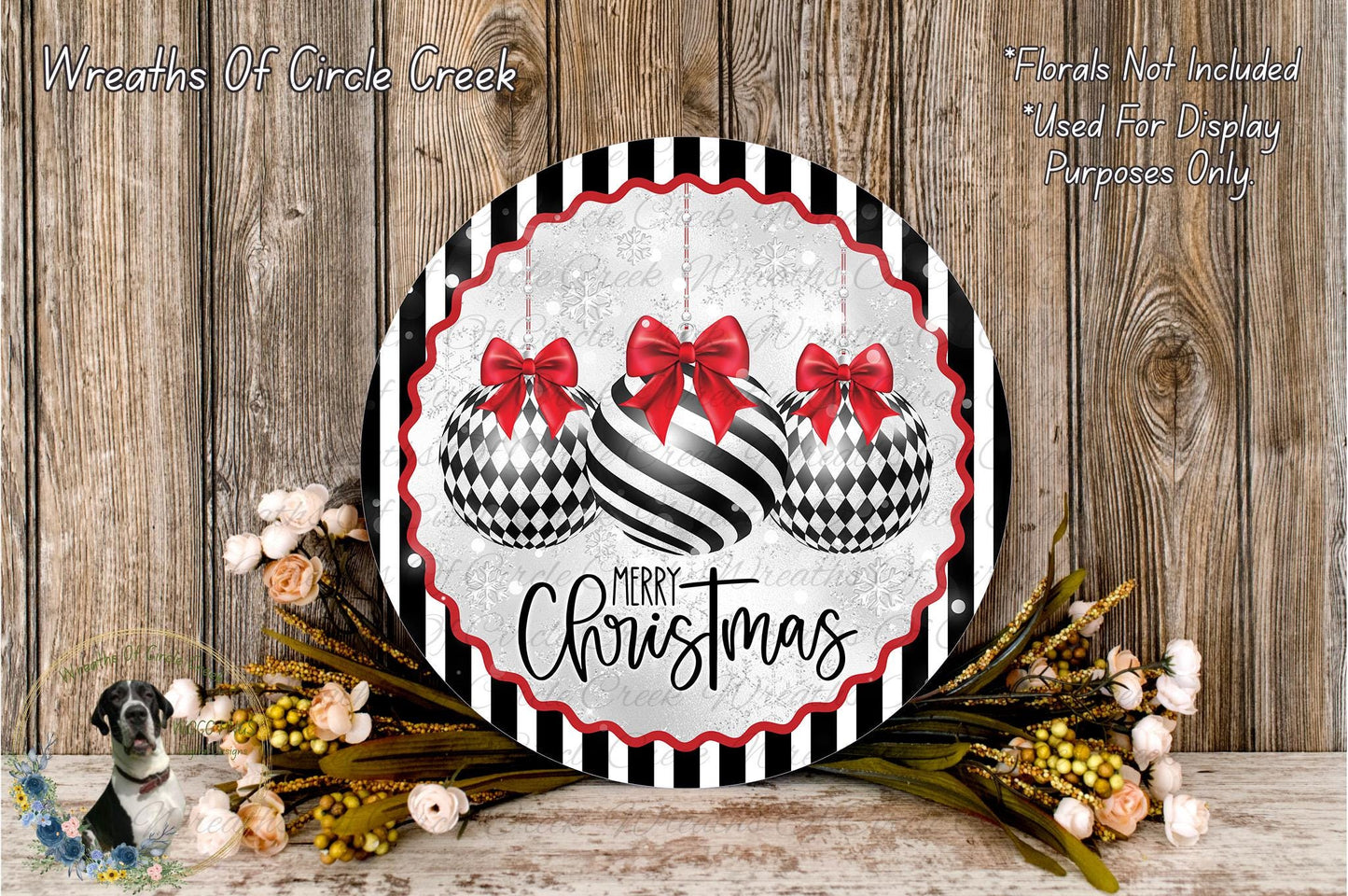 a festive Christmas wreath with a black and white checkered design, adorned with red bows and the text "Merry Christmas". The wreath is placed on a wooden surface, surrounded by a floral arrangement and some greenery.