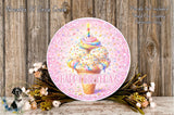 A round birthday wreath with a colorful ice cream cone and a candle on top, surrounded by flowers and a wooden background.