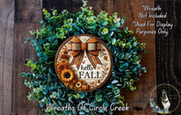 a wreath with a bow and sunflowers on it