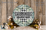 a round sign with the text "GRANDKIDS spoiled here" surrounded by a floral arrangement and some flowers.