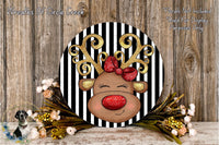 A decorative wreath featuring a red-nosed reindeer with a bow, surrounded by flowers and placed on a wooden surface.