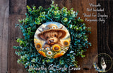 A wreath made of green foliage and yellow flowers, with a large image of a dog wearing a hat and surrounded by sunflowers.