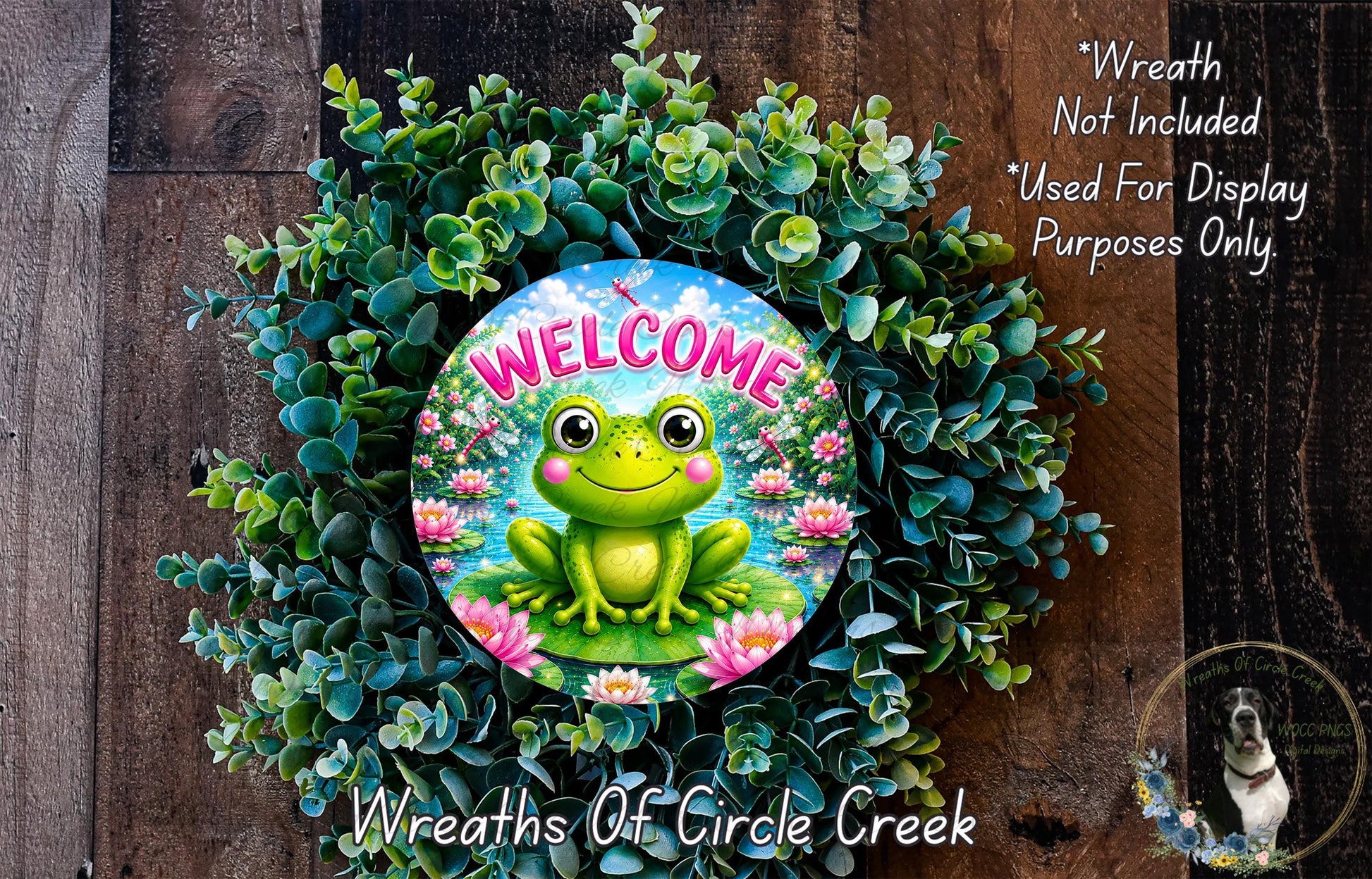 a wreath with a frog sitting on a pond surrounded by greenery. The wreath is placed on a wooden surface, and there is a text overlay that reads "Welcome Wreath Not Included * Used For Display Purposes Only" and "Wreaths of Circle Creek".
