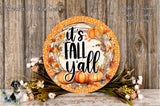 a decorative plate with the text "It's Fall Yall" surrounded by a wreath of autumn leaves and pumpkins. The plate is placed on a wooden surface, and there are flowers and greenery surrounding it.