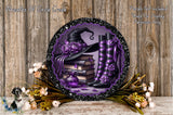 a decorative wreath with a witch's hat, purple boots, and a stack of books, surrounded by flowers and a wooden background.