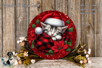 A decorative wreath featuring a sleeping kitten wearing a Santa hat, surrounded by red poinsettia flowers and greenery, placed on a wooden surface.