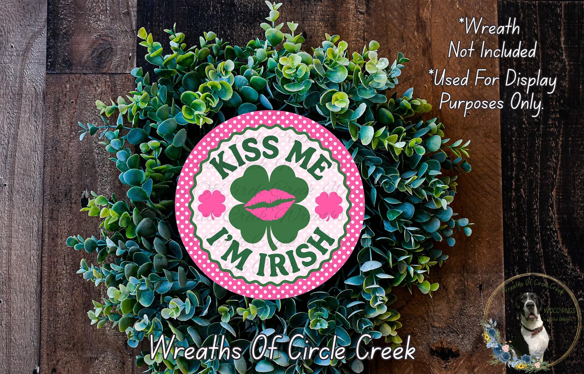 a wreath made of green leaves and a pink circular sign with the text "KISS ME I'M IRISH" and a clover design.