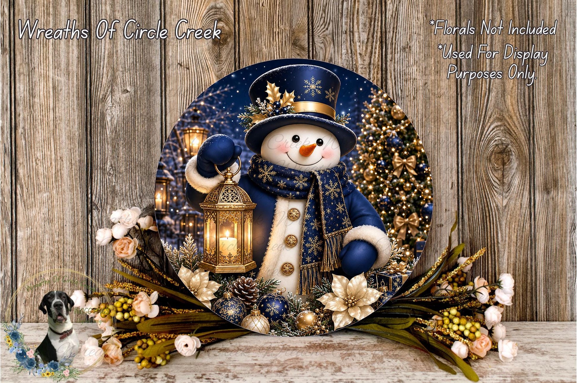 A snowman holding a lantern stands in a wreath of flowers and greenery, with a Christmas tree in the background.