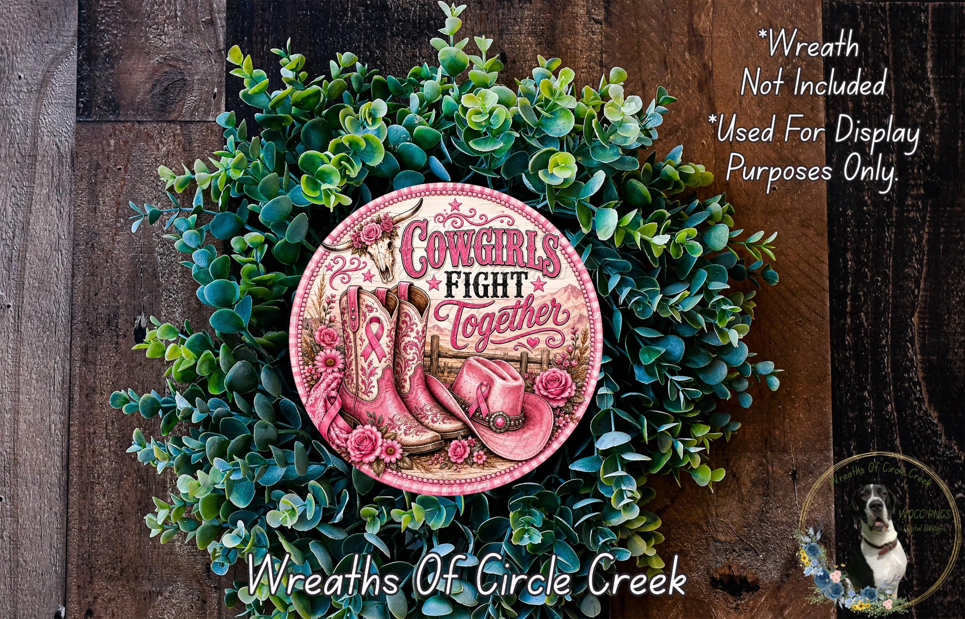 a wreath made of green leaves and a pink cowboy boot with the text "Cows fight together" on it. The wreath is displayed on a wooden surface, and there is a small dog in the bottom right corner of the image.