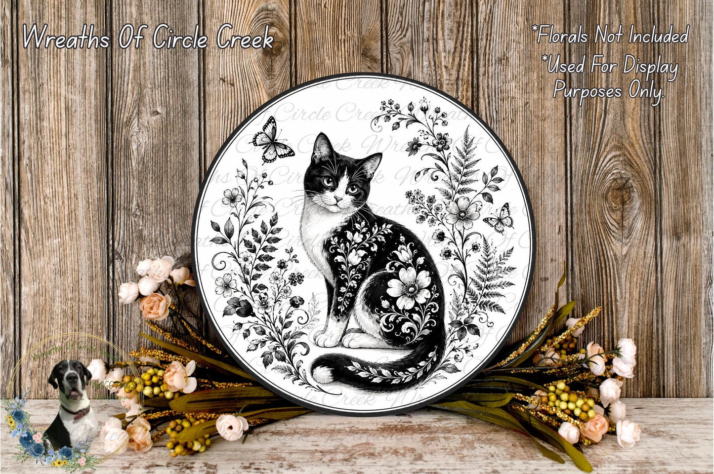 A decorative plate featuring a black and white cat surrounded by floral elements, including flowers and leaves, placed on a wooden surface.