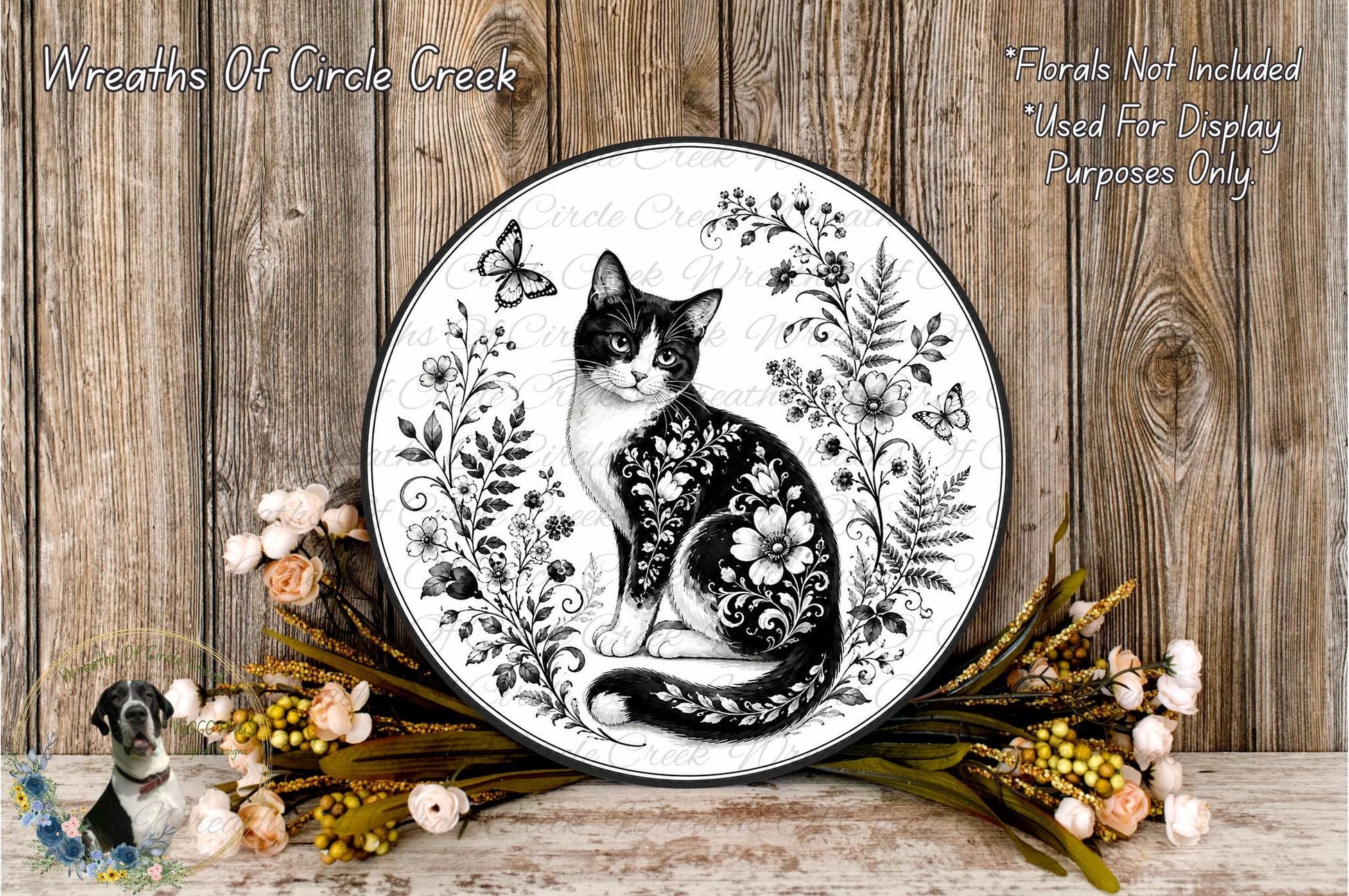 A decorative plate featuring a black and white cat surrounded by floral elements, including flowers and leaves, placed on a wooden surface.