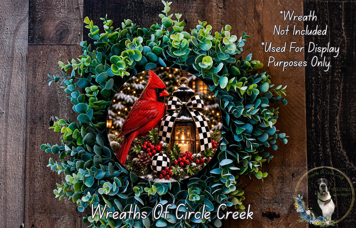 A wreath made of green leaves and red berries, with a red cardinal perched on a branch in the center. The wreath is displayed on a wooden surface, and there is a small dog in the bottom right corner.