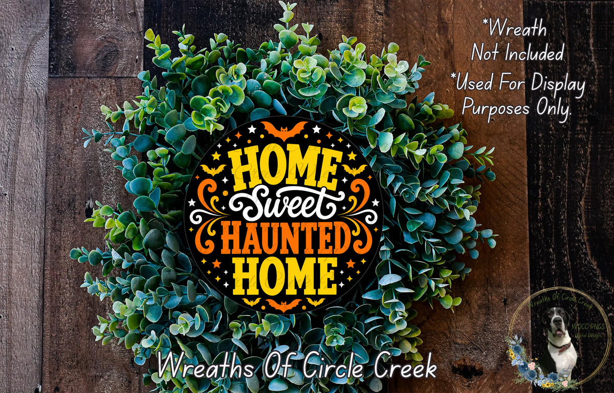 a wreath made of green leaves and flowers, with a decorative text that reads "Home Sweet Haunted Home" in orange and yellow colors.