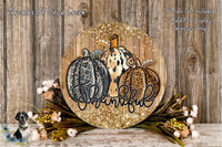 A round wooden sign with a leopard print design and the word "Thankful" written on it, surrounded by autumn foliage and flowers.