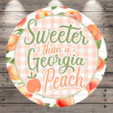 a circular design with a peach pattern and the text "Sweeter than a Georgia Peach" written on it.
