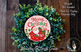 A Christmas wreath made of evergreen branches and featuring a Santa Claus image, with the text "Merry Christmas" displayed on the wreath.
