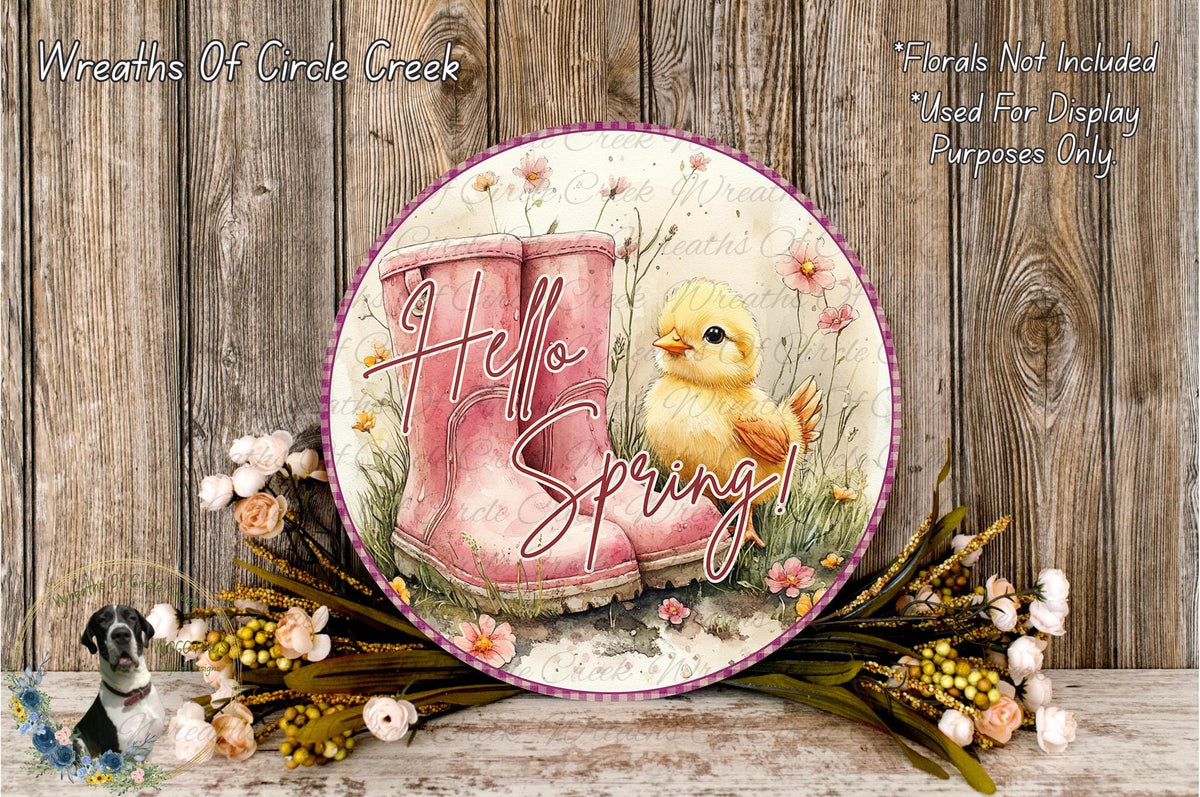 A decorative plate with a yellow chick sitting in a pink boot surrounded by flowers and greenery, with the text "Hello Spring!" displayed on it.