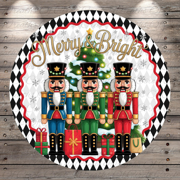 A circular decorative plate with three nutcracker men in colorful outfits standing in front of a Christmas tree. The plate has a black and white diamond pattern around the edges and the text &quot;Merry & Bright&quot; written above the nutcrackers.