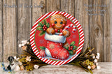 A festive Christmas wreath featuring a gingerbread man in a red stocking, surrounded by flowers and a candy cane.