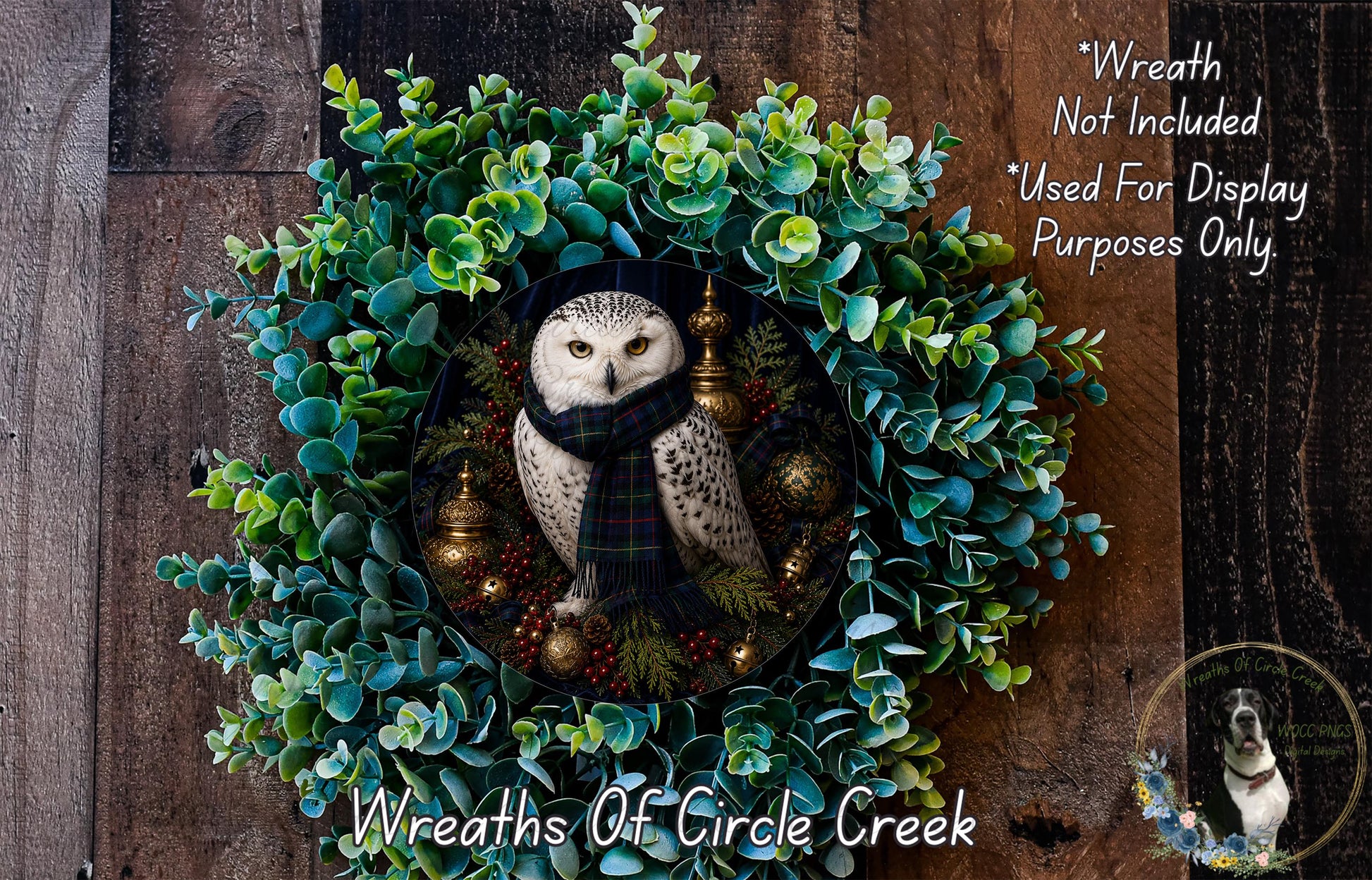 A wreath featuring a white owl wearing a scarf, surrounded by green foliage and ornaments. The wreath is displayed on a wooden surface.