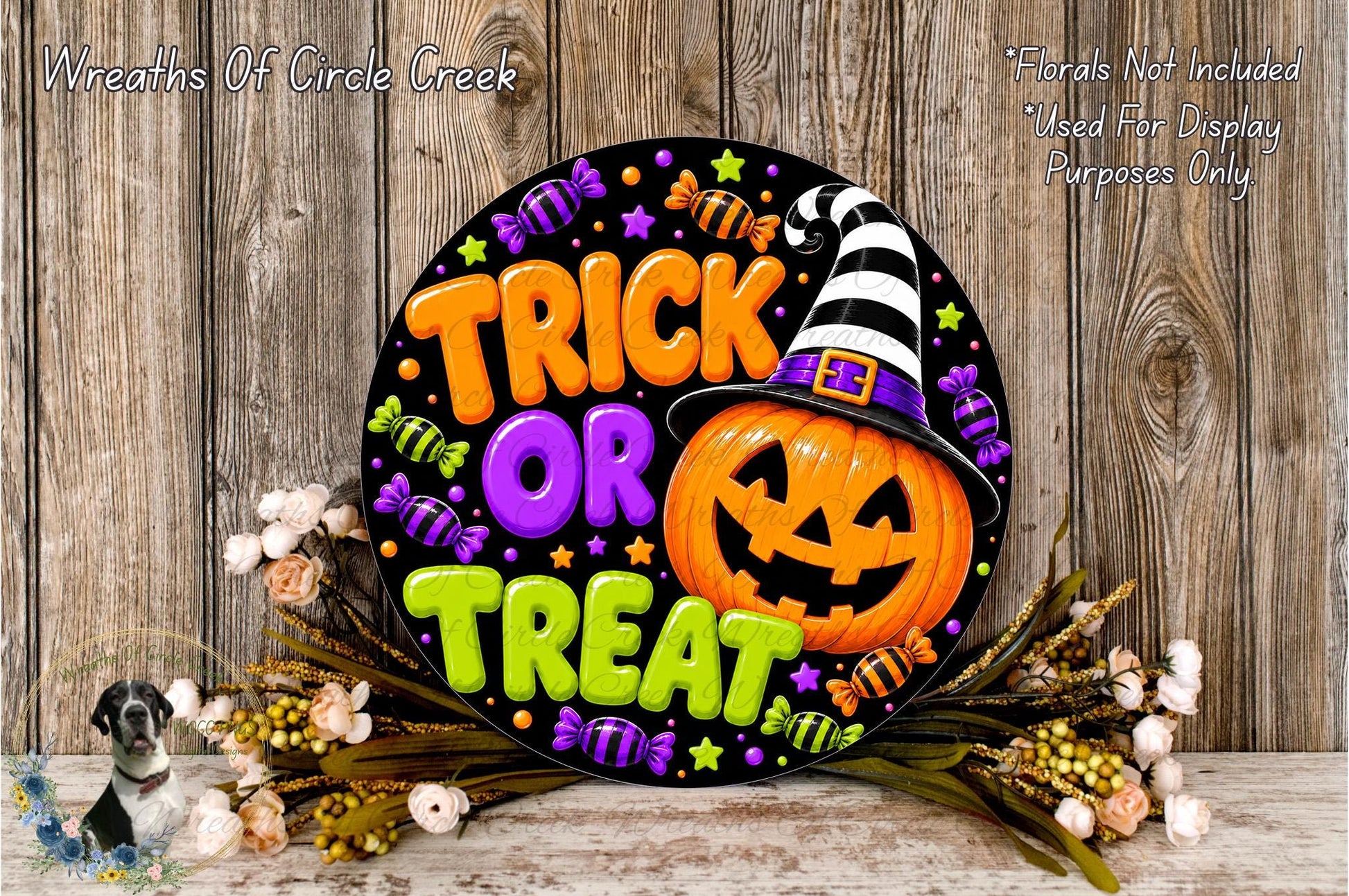 A Halloween-themed sign with the text "TRICK OR TREAT" and a jack-o-lantern wearing a witch's hat, surrounded by candy and flowers.
