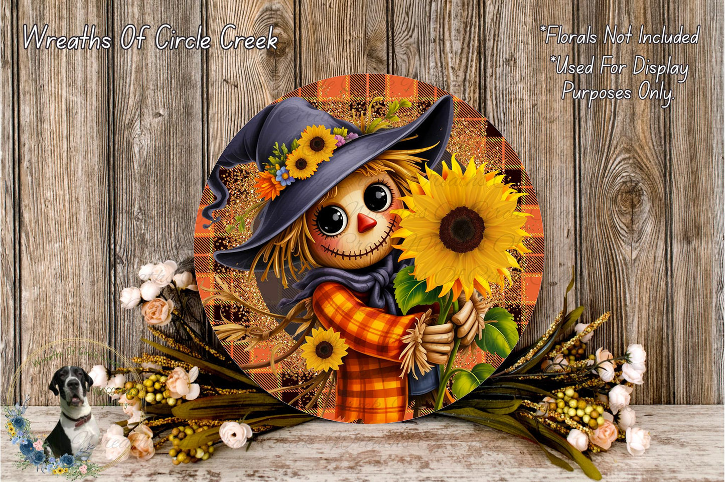 A round, decorative wreath featuring a scarecrow holding a sunflower, surrounded by autumn foliage and flowers.