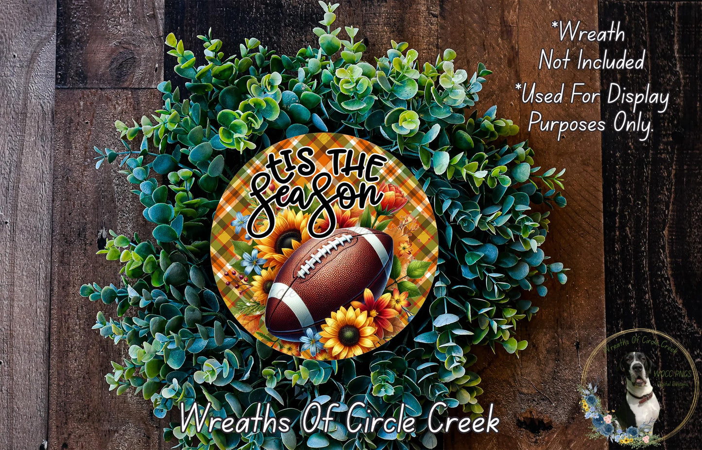 A wreath made of various green plants and flowers, with a football and sunflowers as the main decorative elements. The wreath is displayed on a wooden surface.