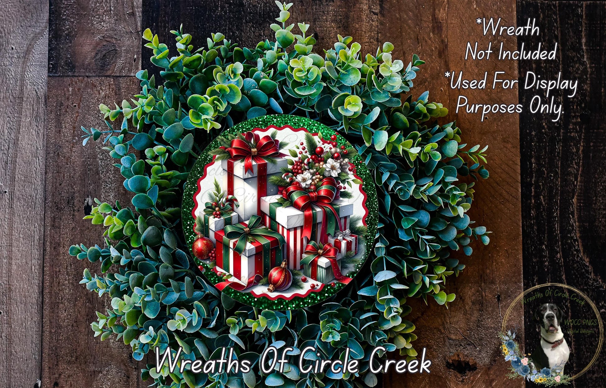 A wreath made of evergreen branches and wrapped gifts, with a red bow on top, is displayed on a wooden surface.