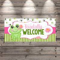 a welcome sign with a frog sitting on top of it