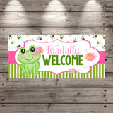 a welcome sign with a frog sitting on top of it