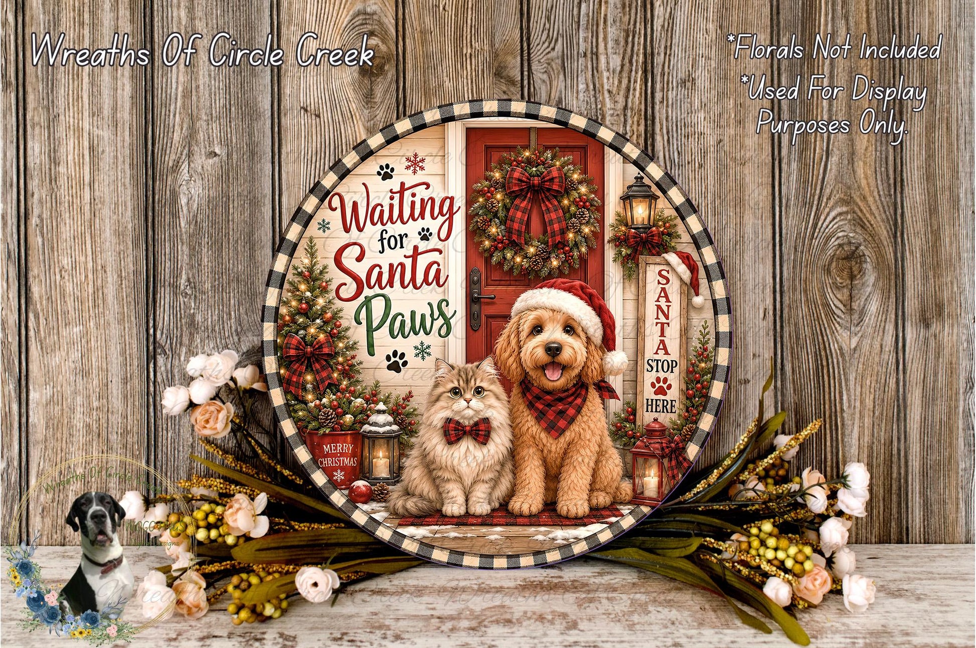 A decorative plate featuring a dog and a cat, with a Christmas wreath and other holiday-themed elements, placed on a wooden surface.