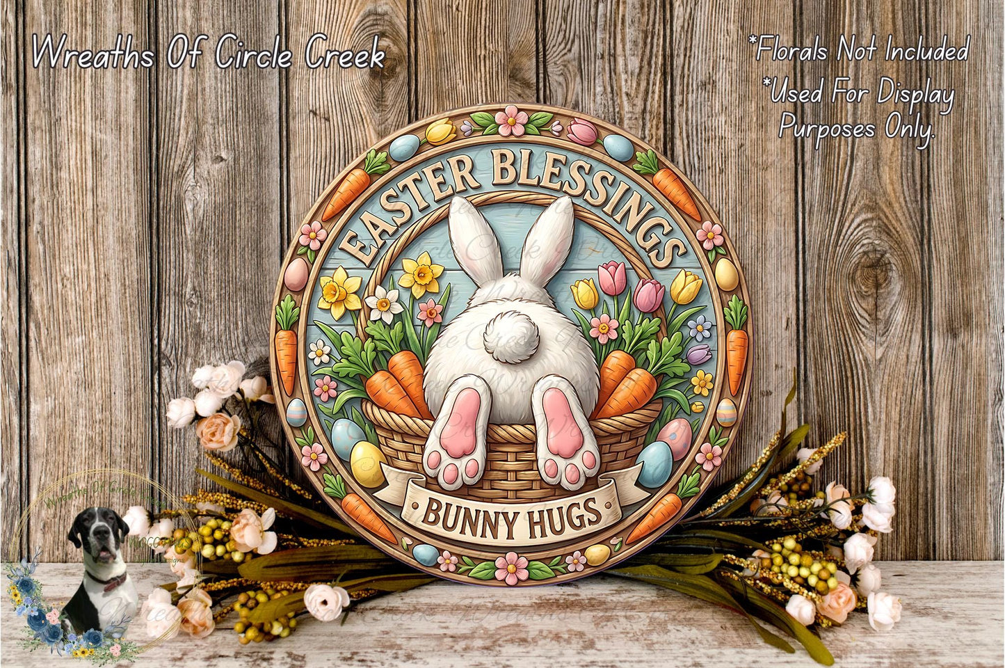 a decorative Easter-themed sign with a bunny sitting in a basket filled with flowers and carrots. The sign has a floral border and the text "Easter Blessings Bunny Hugs" written on it. The sign is surrounded by a wreath of flowers and a bunch of carrots, creating a festive and cheerful atmosphere.